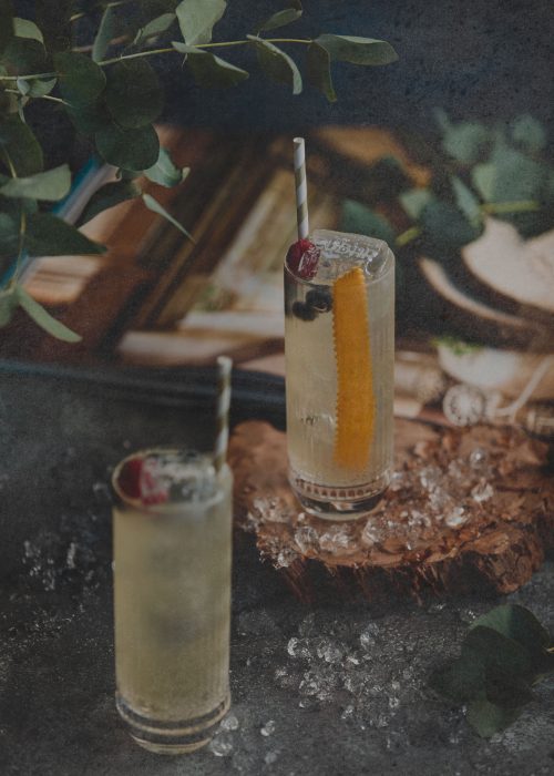 side view of alcohol cocktail with kiwi in a golden glass on a w